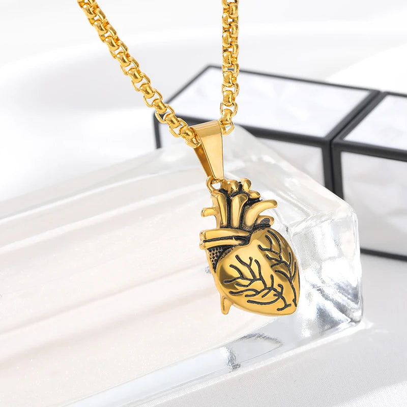 Gold heart-shaped pendant necklace on a clear stand with a white background